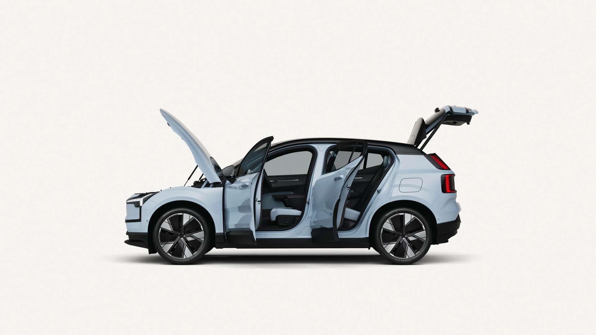 Full side profile of the 2026 Volvo EX30 in Cloud Blue, featuring 19-inch Aero wheels, high ground clearance, and a sleek black contrast roof.